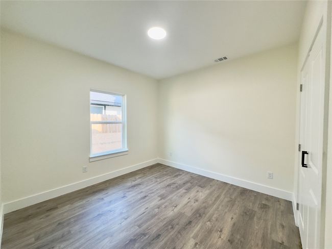 Unfurnished bedroom featuring baseboards, visible vents, and wood finished floors | Image 12