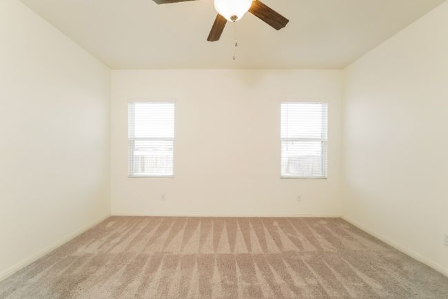 Unfurnished room with carpet, healthy amount of natural light, and a ceiling fan | Image 12