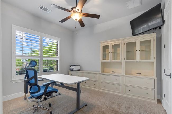 Home office featuring carpet, visible vents, a ceiling fan, and baseboards | Image 23