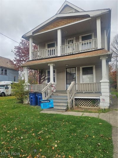 View of front of property with a front yard, a porch, and a balcony | Image 1