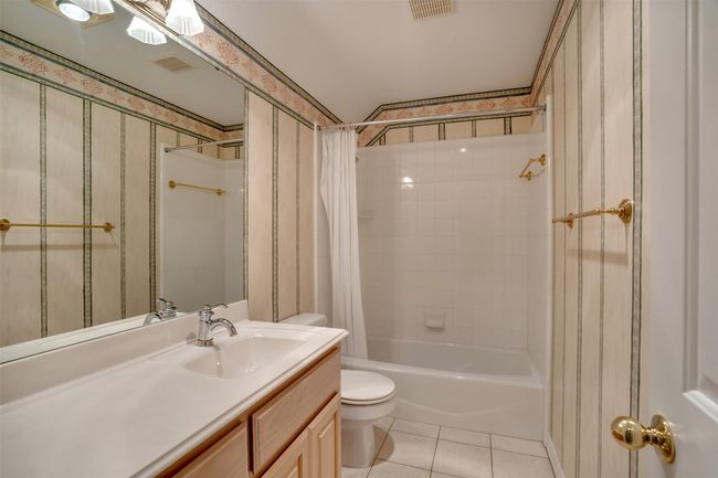 Full bath featuring toilet, tile patterned floors, shower / bath combo, and vanity | Image 29