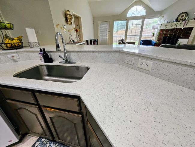 Kitchen featuring lofted ceiling and light stone counters | Image 8