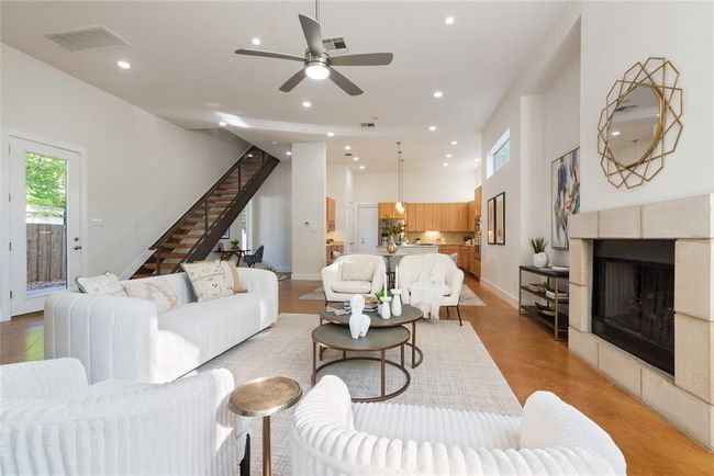 Living room with stairway, a tiled fireplace, recessed lighting, ceiling fan, and baseboards | Image 6