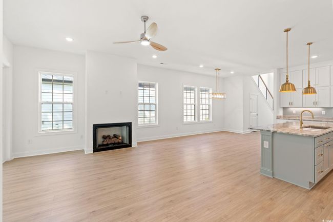Kitchen featuring a fireplace, healthy amount of natural light, ceiling fan, light wood finished floors, and recessed lighting | Image 6