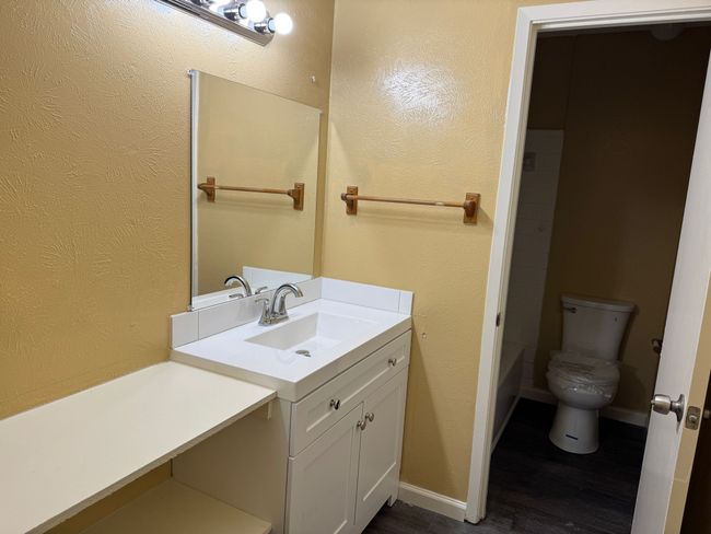 Full bath with vanity, wood finished floors, and a textured wall | Image 16