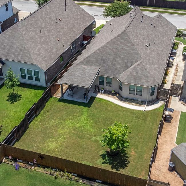 Aerial view of big back yard featuring custom covered patio. | Image 40