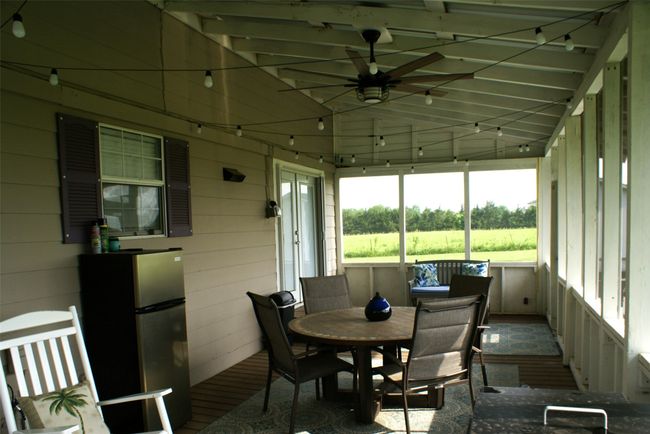 Sunroom with a ceiling fan, outdoor dining area, vaulted ceiling, and a rural view | Image 19