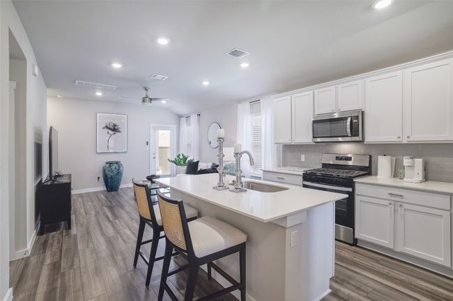 Kitchen featuring appliances with stainless steel finishes and a breakfast bar | Image 10