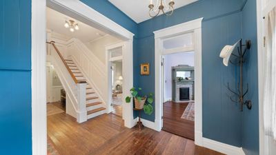 Foyer entrance featuring a notable chandelier, a fireplace, hardwood / wood-style flooring, and crown molding | Image 2