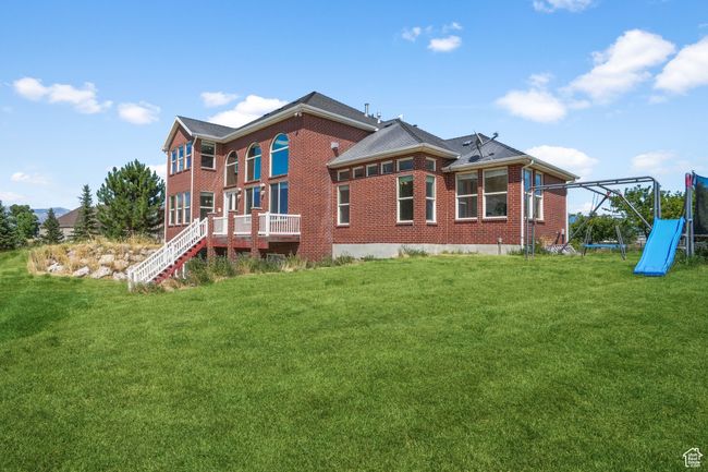 Back of house featuring a yard, a playground, and brick siding | Image 29