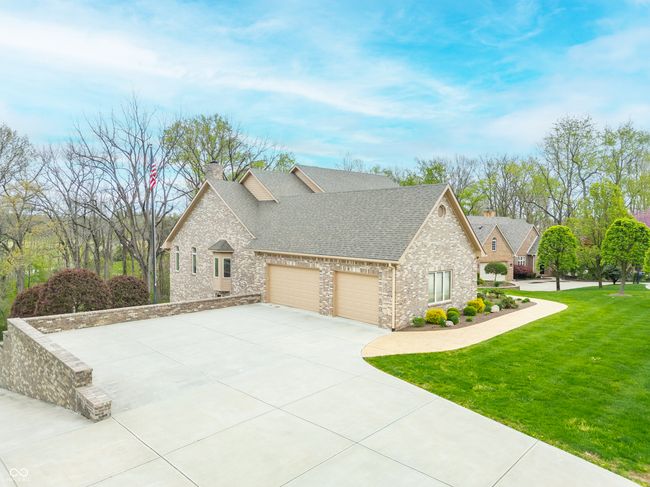 view of side of property featuring a shingled roof, a yard, driveway, a chimney, and an attached garage | Image 5