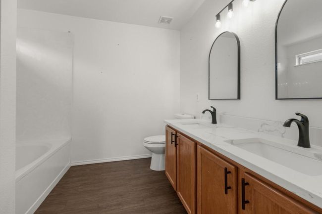 Bathroom featuring toilet, visible vents, wood finished floors, and a sink | Image 13