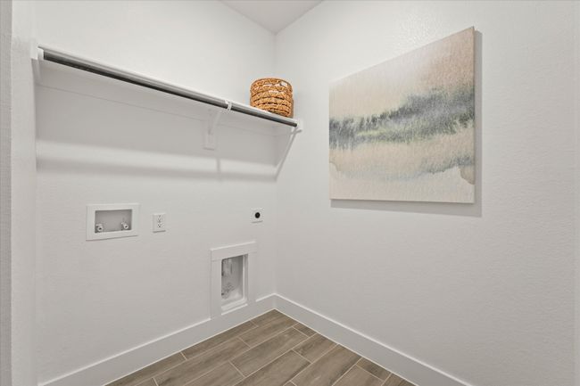 Laundry area featuring hookup for an electric dryer, washer hookup, and wood tiled floors | Image 9