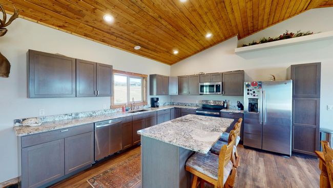 Kitchen featuring wooden ceiling, appliances with stainless steel finishes, lofted ceiling, and a sink | Image 6