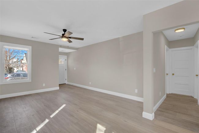 Spare room with light wood-style floors, visible vents, ceiling fan, and baseboards | Image 11