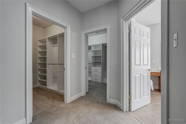 Two walk-in closets professionally outfitted by Closet Designs for optimal organization. | Image 33