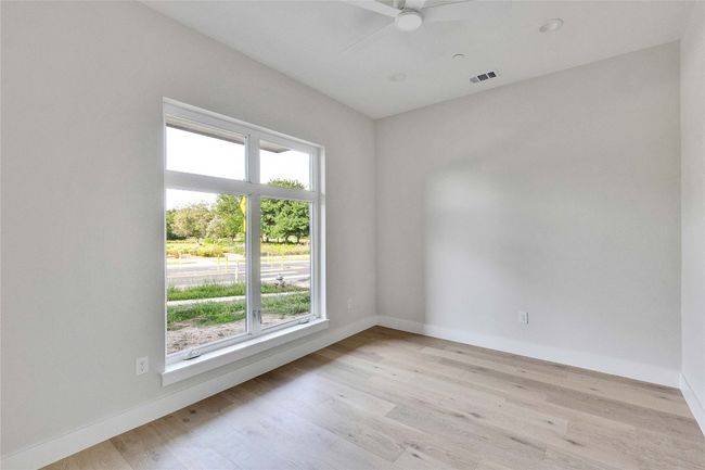 Empty room with plenty of natural light, light wood-style flooring, and ceiling fan | Image 12