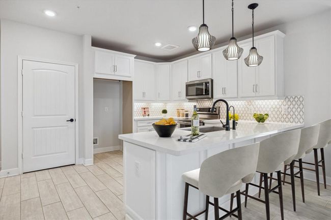 Virtually Staged. Gorgeous kitchen with quartz countertops, shaker style cabinetry, under-cabinet lighting, and a breakfast bar with pendant lighting. | Image 4