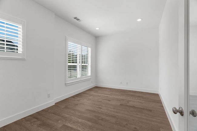 Empty room with dark wood-type flooring, baseboards, and recessed lighting | Image 7