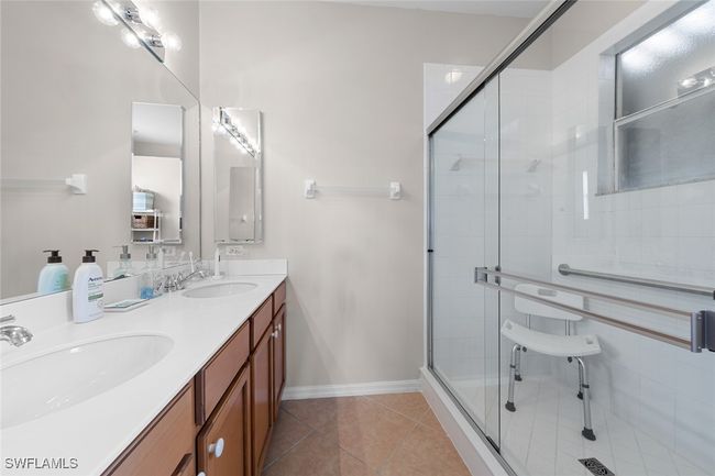 Full bathroom with double vanity, tile patterned floors, a stall shower, and a sink | Image 6