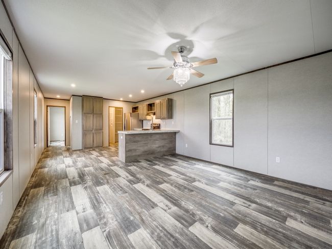 Kitchen with ceiling fan, light wood-style flooring, a peninsula, and freestanding refrigerator | Image 5
