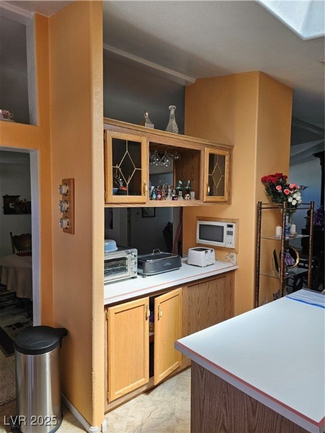 Kitchen featuring a toaster, light countertops, and open shelves | Image 22