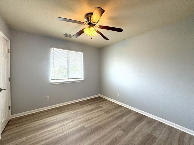 Unfurnished room with ceiling fan, a textured ceiling, and wood finished floors | Image 11