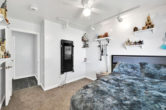 Bedroom featuring track lighting, carpet, baseboards, and ceiling fan | Image 24