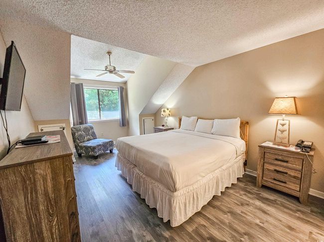 Bedroom featuring a textured ceiling, dark wood finished floors, a ceiling fan, and baseboards | Image 20