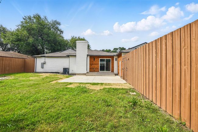 Rear view of property featuring a patio area, central AC unit, and a chimney | Image 38