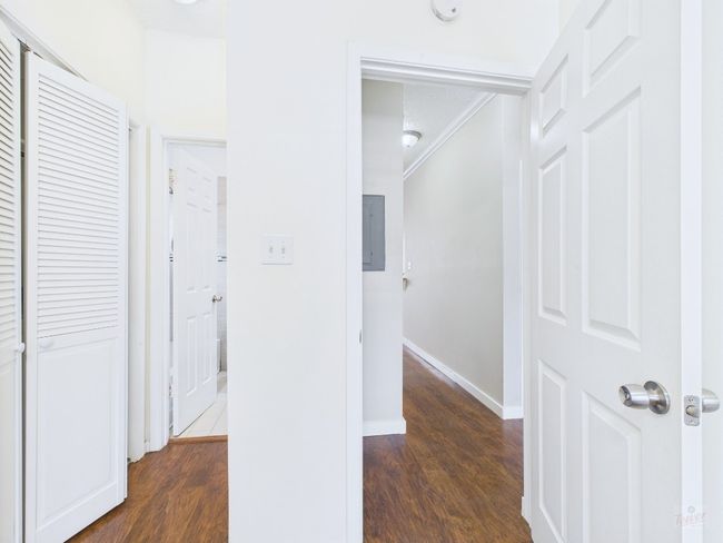 Hall featuring wood finished floors, electric panel, and crown molding | Image 19