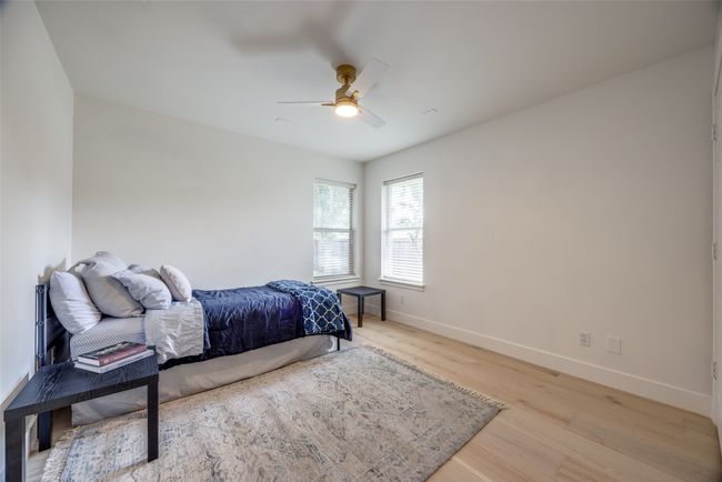 Bedroom with light wood finished floors and ceiling fan | Image 29