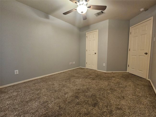 Spare room featuring a ceiling fan, carpet, and a smoke detector | Image 23