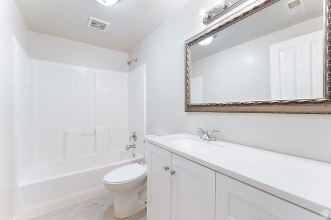 Bathroom featuring vanity, tile patterned floors, and shower / washtub combination | Image 33