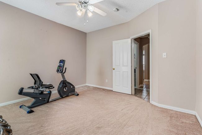 Bedroom 3 with carpet and a ceiling fan. Walk-in closet. | Image 30