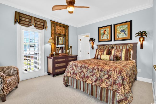 Bedroom featuring light carpet, crown molding, and a ceiling fan | Image 31