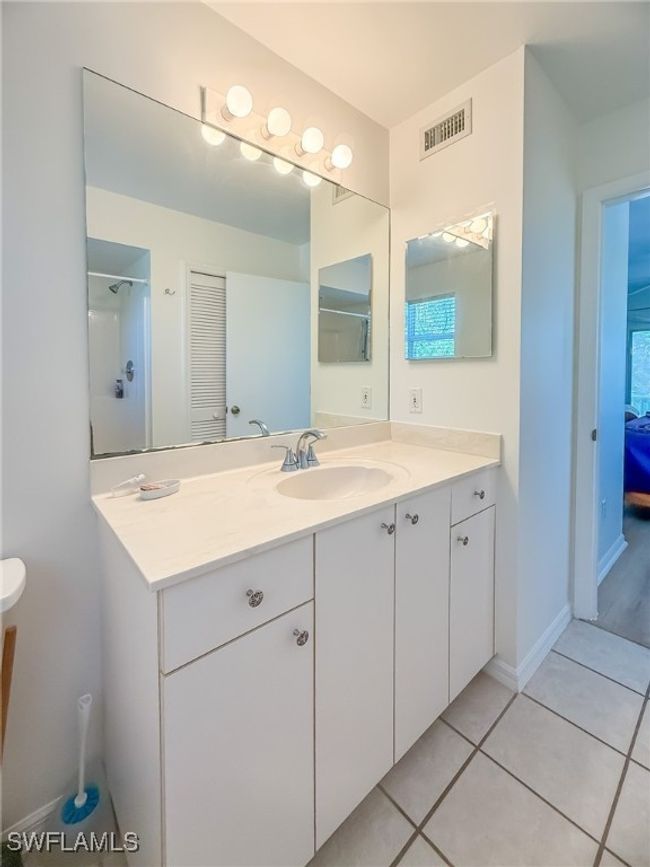 Bathroom with vanity, tile patterned flooring, visible vents, and baseboards | Image 36
