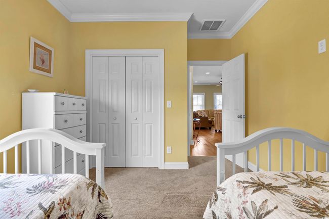Bedroom with ornamental molding, a closet, and carpet flooring | Image 15