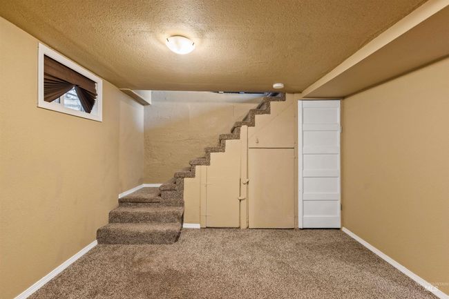Finished basement featuring stairway, a textured ceiling, and carpet floors | Image 29