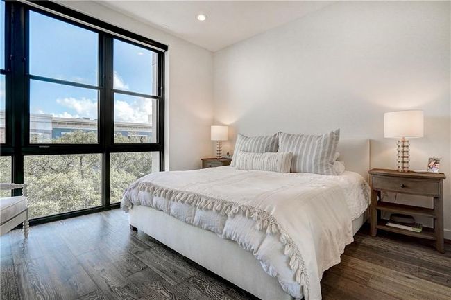Beautiful tree top views from the primary bedroom. Automatic window shades make it easy to shut out the light for restful sleep. | Image 13