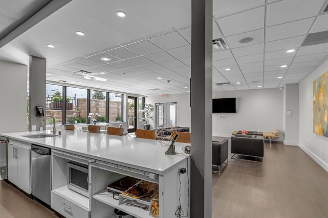 Kitchen featuring a sink, a drop ceiling, open floor plan, wood finished floors, and light countertops | Image 20