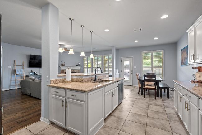 Kitchen featuring a sink, dishwasher, plenty of natural light, white cabinets, and recessed lighting | Image 17