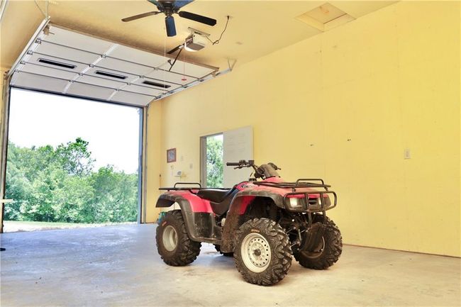 Garage with a garage door opener and a ceiling fan | Image 41