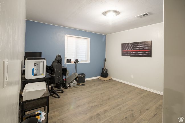 Home office featuring baseboards, wood finished floors, and visible vents | Image 19