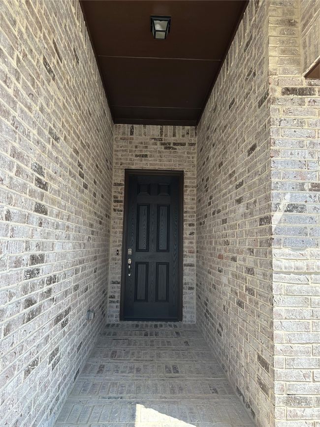 View of exterior entry featuring brick siding | Image 12