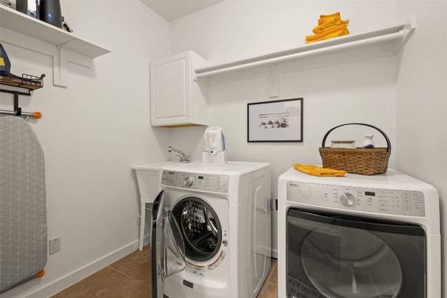 Laundry area with cabinet space, separate washer and dryer, and tile patterned floors | Image 24