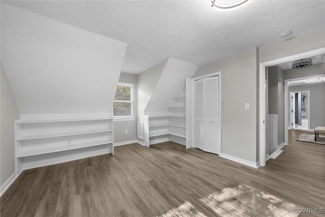 2nd floor bedroom with wood finished floors, a textured ceiling, and vaulted ceiling | Image 31