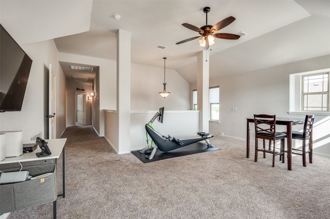 Exercise room featuring carpet, a ceiling fan, lofted ceiling, and attic access | Image 13