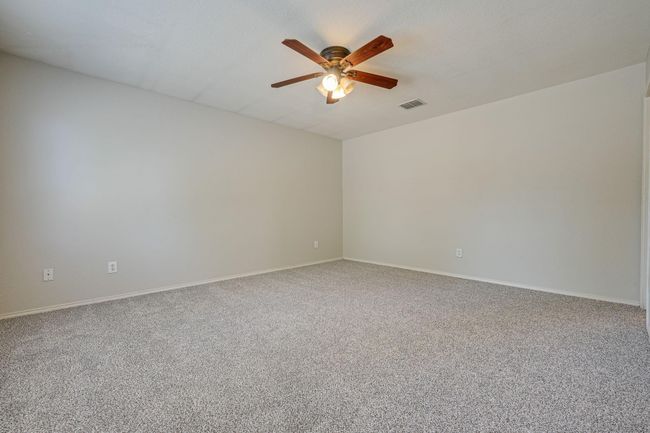 Carpeted spare room featuring ceiling fan and baseboards | Image 15