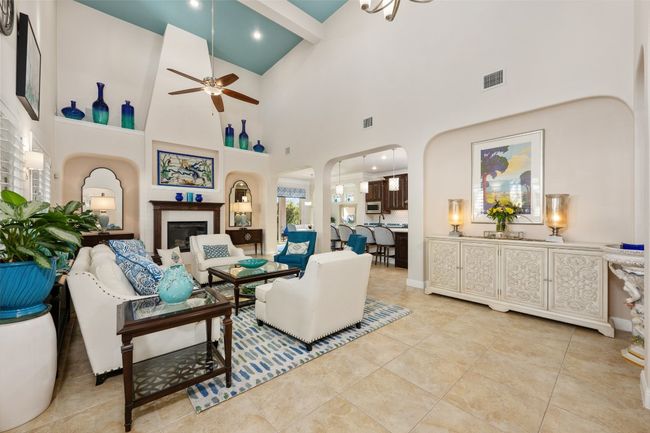Great room with ceiling fan, a fireplace, and high vaulted ceiling. | Image 5